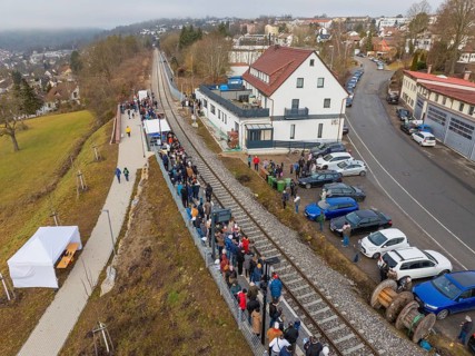 A train station with many people, located in an urban area with roads, opening of the Hermann Hesse