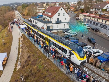 Zug at an event with people and rain of confetti, surrounded by vehicles and buildings, opening of