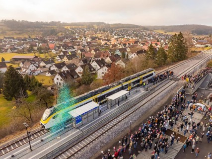 Train arrival at a busy train station with crowds and city views, opening of the Hermann Hesse