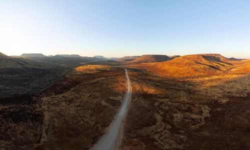 Aerial view, road leading through dry desert landscape, hills in Damaraland, Namibia