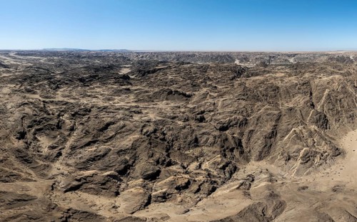Aerial view, dry barren mountains in Moon Valley, rocky landscape ridged by erosion, Namib-Naukluft