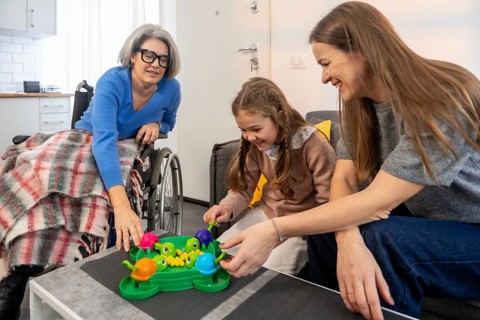 Happy multi generational family playing a fun board game together, connecting and sharing joyful