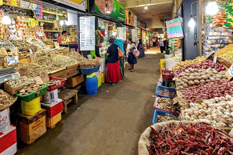Bustling marketplace full of spices and vegetables with people in narrow corridors, The old market