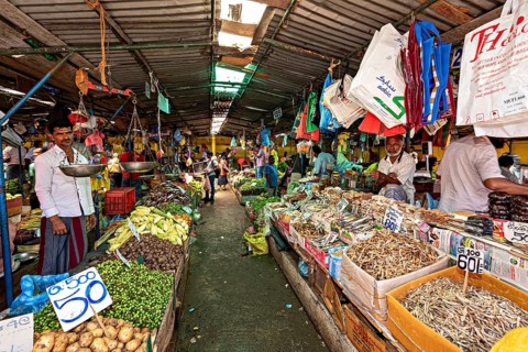 A busy market with various vegetable offerings and countless hanging rooms, The old market halls of