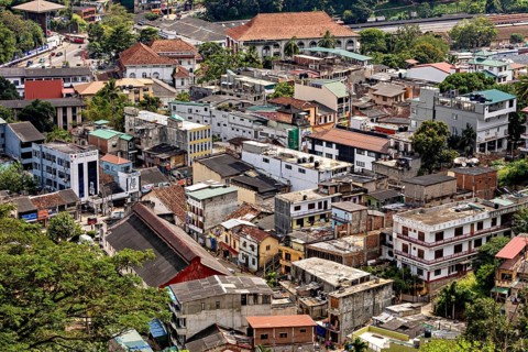 City view with densely built houses, green surroundings and various architectural styles, view of