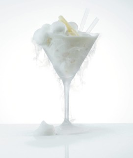 Lemon ice cream in a frosted cocktail glass, the cold creates ice fog on the glass, studio shot