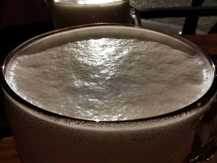 Close-up of a beer glass with creamy foam under evening light, Pilsen, Czech Republic