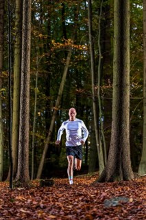 Man in a training session, trail running outdoors, healthy lifestyle, colorful autumn forest,