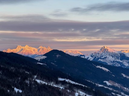 Alpine glow at sunset, mountain peaks of the Loferer Steinberge and Kitzbühler Horn in winter,