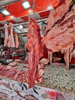 Close-up of pieces of meat and camel's head (camelum) at a lively butcher's stall with red décor,