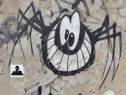 Graffiti of a stylised spider (araneae) on a weathered urban wall, Morocco