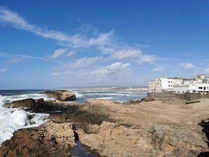 Rocky coast with buildings and clear sky in the distance, Essaouira, Morocco