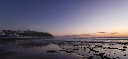 Sunset over a quiet beach, shimmering waves in evening light, Morocco