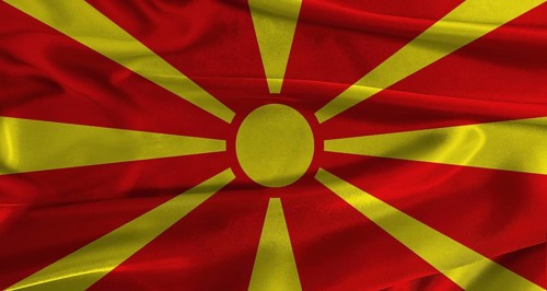 Flag of North Macedonia with fabric textured background. Close up of National flag of North
