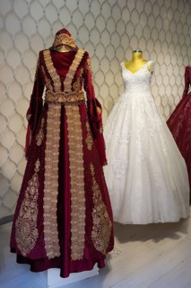 Two magnificent wedding dresses, one red with gold embroidery and one classic white dress,