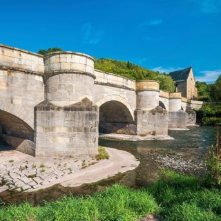 13th century medieval stone bridge across the Werra river, in the back the Liborius chapel,