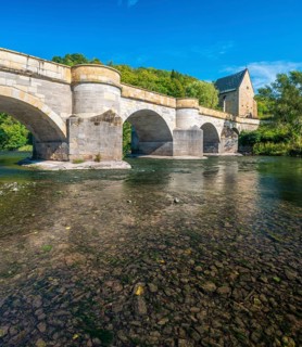 13th century medieval stone bridge across the Werra river, in the back the Liborius chapel,