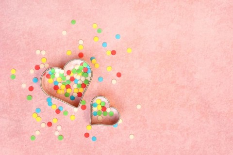 Two heart-shaped baking pans and sugar confetti