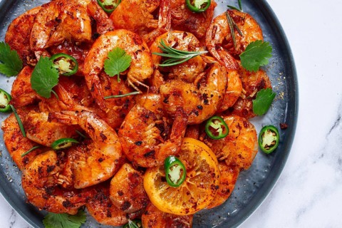 Grilled shrimp, unpeeled, headless, with spices, on a marble table, homemade, no people