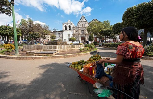 Parque Centroamérica or Parque Central, a Mayan woman in traditional dress selling oranges, in the