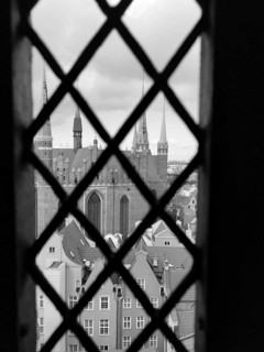 View of church towers and urban architecture through a lattice window, Gdansk, Poland