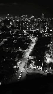 City view at night with illuminated streets and distinctive skyline in the background, black and