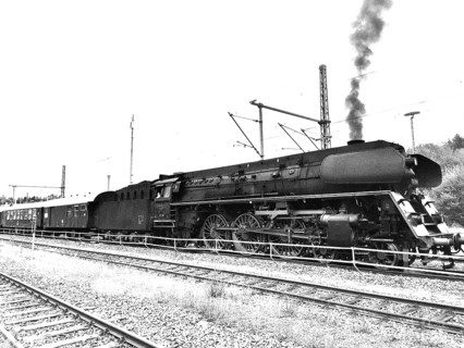 Historic steam locomotive pulls wagons onto tracks, smoke rises, Upper Franconia