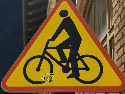 Traffic warning sign with a black bicycle symbol on a red triangle, Poland