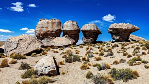 Remarkable rock formations rise in a dry desert landscape under clear skies, The landscape of the