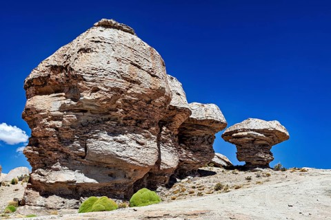 Impressive rock formations rise in a vast desert landscape under blue skies, The Landscape of the