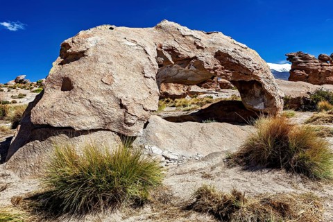 Natural stone arch in a dry desert landscape under bright blue sky, The landscape of the Altiplano