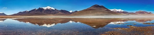 Wide panoramic view of mountains reflecting in the still lake, with snow-capped peaks, The Laguna