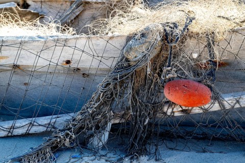 Close-up view of old fishing net hanging on boat, Oman