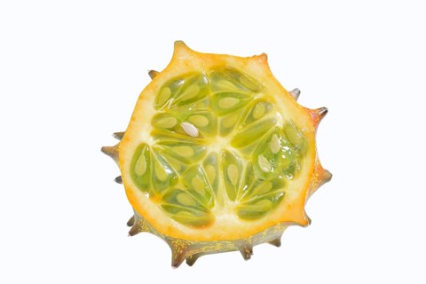 Horned cucumber, kiwano or horned melon (Cucumis metuliferus), sliced fruit on a white background,