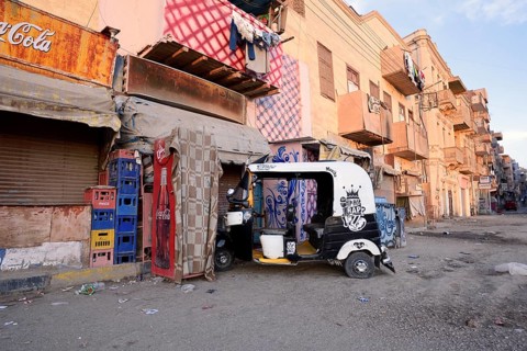 Street and a parked tuk-tuk in front of a shop, Esna, Egypt