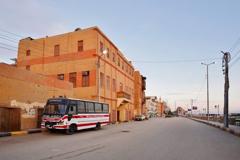 Bus parked on a street and houses, Esna, Egypt