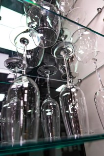 Showcase with elegant wine glasses on glass shelves