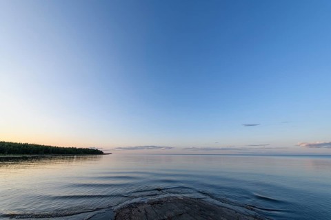 Far-reaching view of the quiet lake Vänern with gently sloping granite rocks archipelago under calm