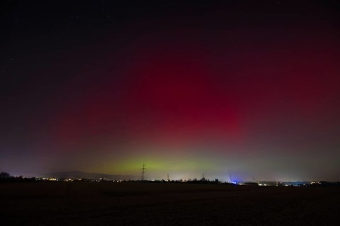 Northern lights (aurora borealis) glow red and green in the evening sky over Germany, Frankfurt am
