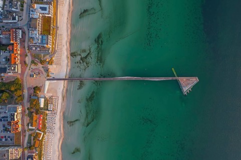 Aerial view over Seebrücke, pier and sandy beach at seaside resort Scharbeutz along the Baltic Sea,