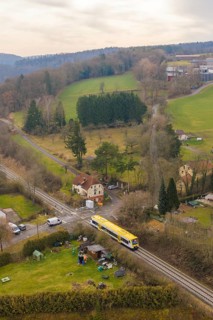 Rural scene with yellow train in green countryside and scattered houses, acceptance of the Hermann