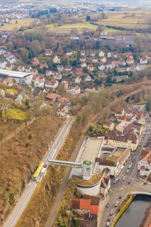 Panorama of city with railroad tracks, hills and river, surrounded by dense residential