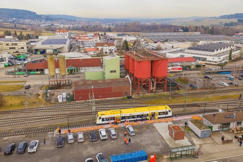 Aerial view of an industrial area with yellow train and large building structures, acceptance of