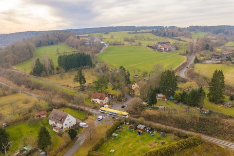 Aerial view of a rural area with trains, fields and small villages in the background, departure of