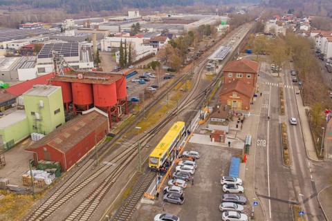 Industrial area with train station and train, surrounded by factories and buildings, shows urban
