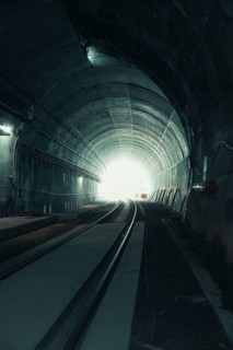 View through a dark tunnel with light at the end. Atmospheric and deserted, acceptance of the