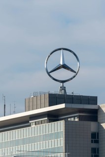Mercedes-Benz logo over a modern building with blue sky, Mercedes Star, Stuttgart-Untertürkheim,