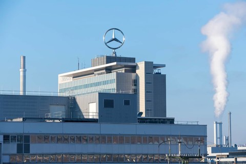 Large industrial building with Mercedes logo, smoking chimney, under blue sky, Mercedes Star,