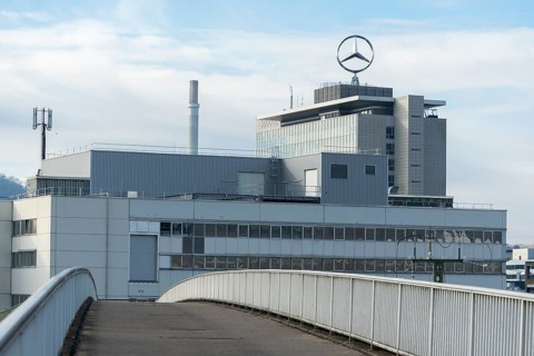 Building with Mercedes logo and bridge under slightly cloudy sky, Mercedes Star,