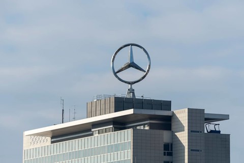 Mercedes-Benz logo over modernly designed building and cloudy sky, Mercedes Star,